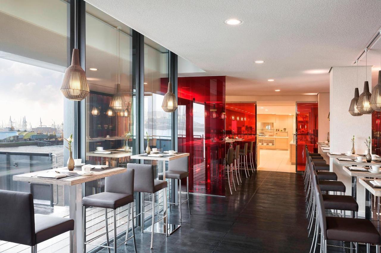 מלון The Westin Hamburg Elbphilharmonie מראה חיצוני תמונה The photo showcases a modern restaurant interior characterized by sleek design and contemporary decor. The space features a combination of large windows allowing natural light to filter in, creating an open and airy atmosphere. The walls are accented
