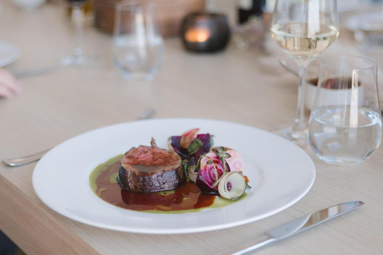 מלון The Westin Hamburg Elbphilharmonie מראה חיצוני תמונה The photo shows a beautifully presented plate of food, featuring a piece of meat, likely a fillet, sliced neatly and arranged at the center. It is accompanied by a rich, glossy sauce that pools around the meat. Surrounding the meat are colorful edibl
